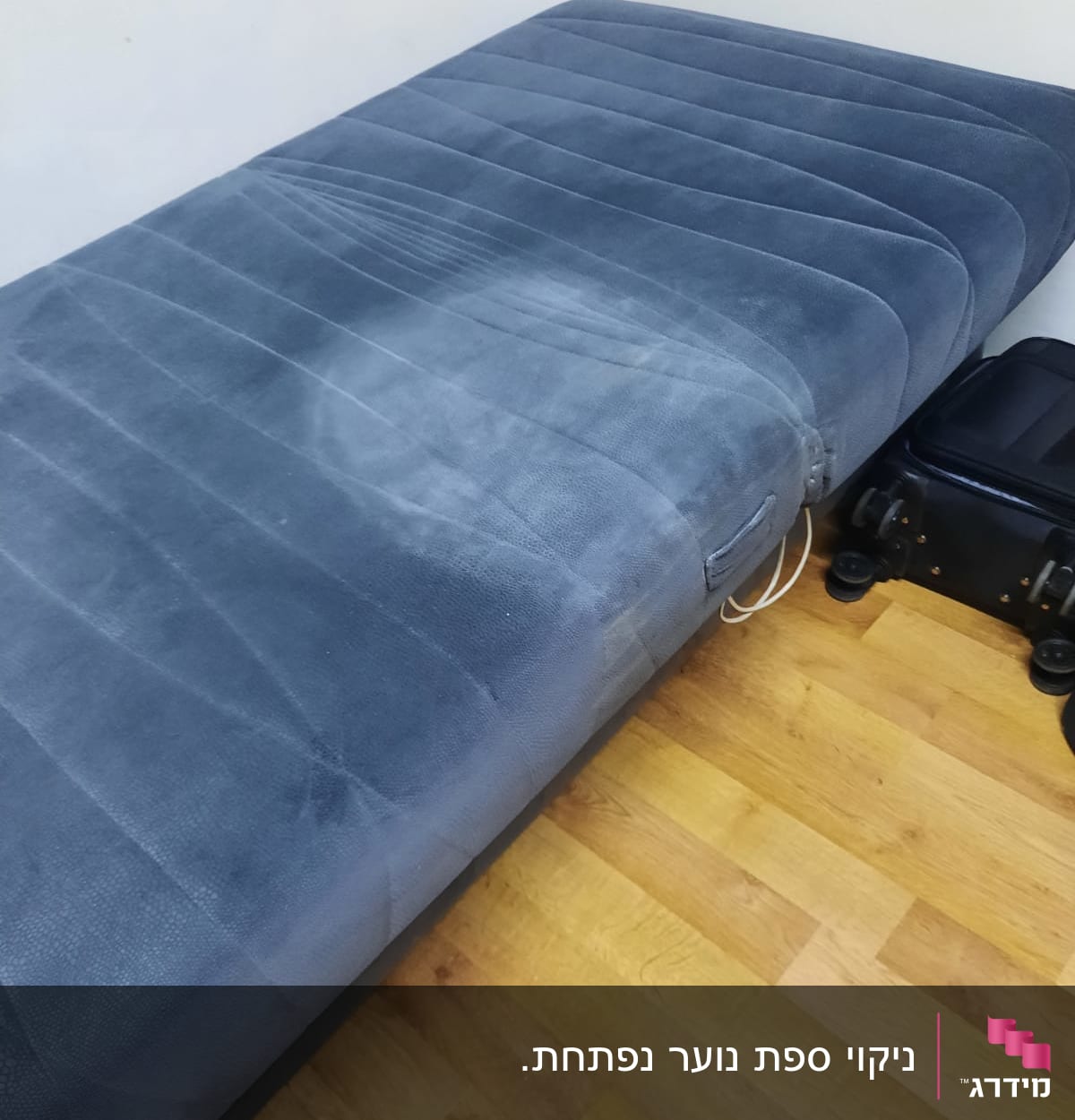 מזרן כחול עם כתם על רצפת עץ
